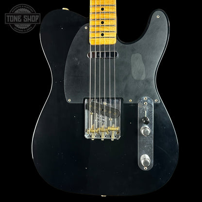Black electric guitar with a yellow fretboard on a black background, featuring the Tone Shop logo.