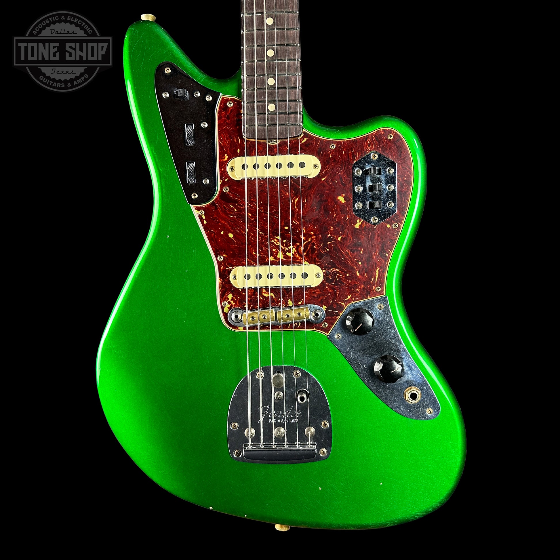 Green electric guitar with a black background, featuring the Tone Shop logo.