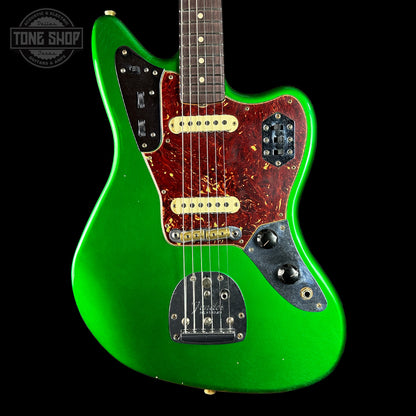 Green electric guitar with a black background, featuring the Tone Shop logo.