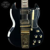 Black electric guitar with gold hardware on a black background, featuring the Gibson logo.