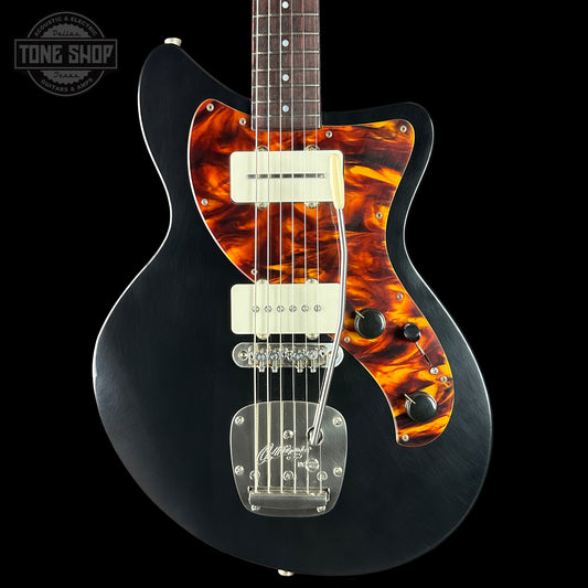 Black electric guitar with tortoiseshell pickguard on a black background, featuring 'Tone Shop' logo.