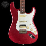Red electric guitar with a white pickguard on a black background, featuring the Tone Shop logo.