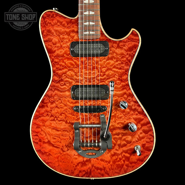 Electric guitar with a quilted orange finish on a black background, featuring the Tone Shop logo.