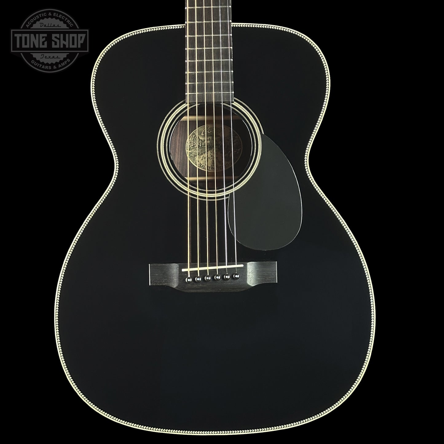 Black acoustic guitar on a black background with 'Tone Shop' logo.