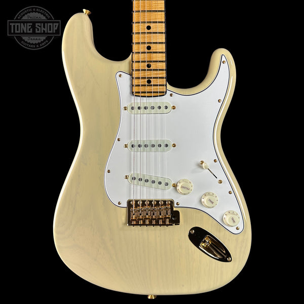 Electric guitar with a blonde finish on a black background, featuring the Tone Shop logo.