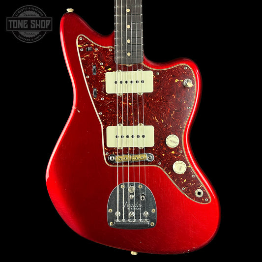 Red electric guitar with a visible brand logo on a black background