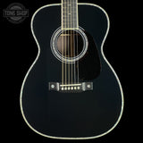 Black acoustic guitar on a black background with 'Tone Shop' logo.