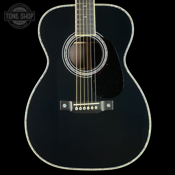 Black acoustic guitar on a black background with 'Tone Shop' logo.