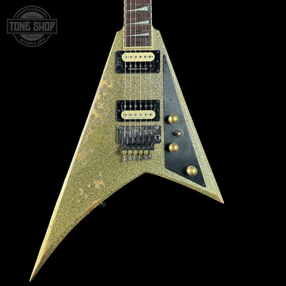 V-shaped electric guitar with a textured finish on a black background, featuring 'Tone Shop' branding.