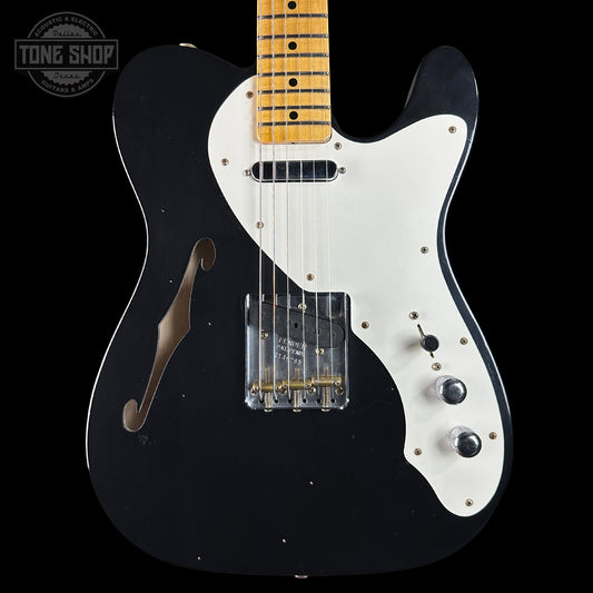 Black and white electric guitar with a visible brand logo in the corner.