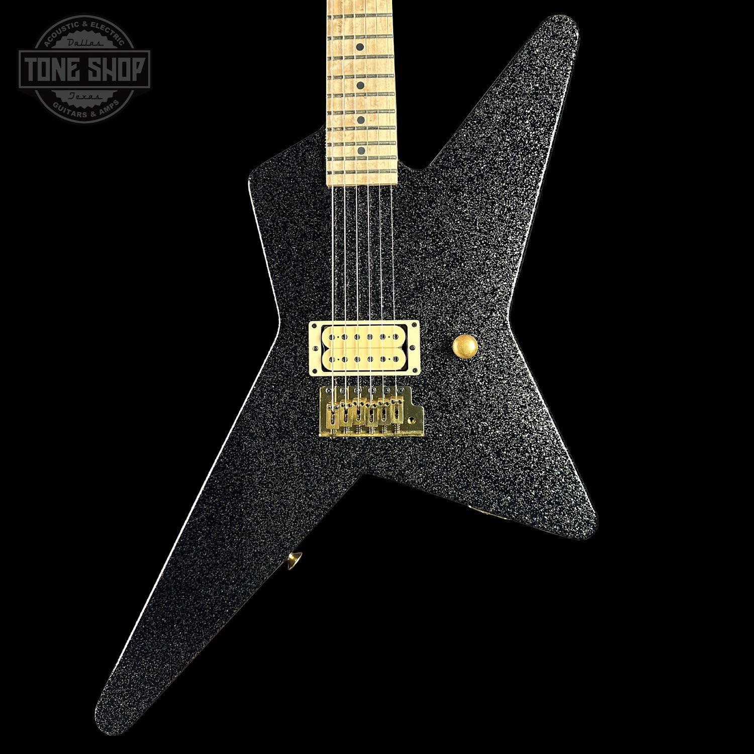 Black electric guitar with gold hardware on a black background, featuring 'Tone Shop' logo.