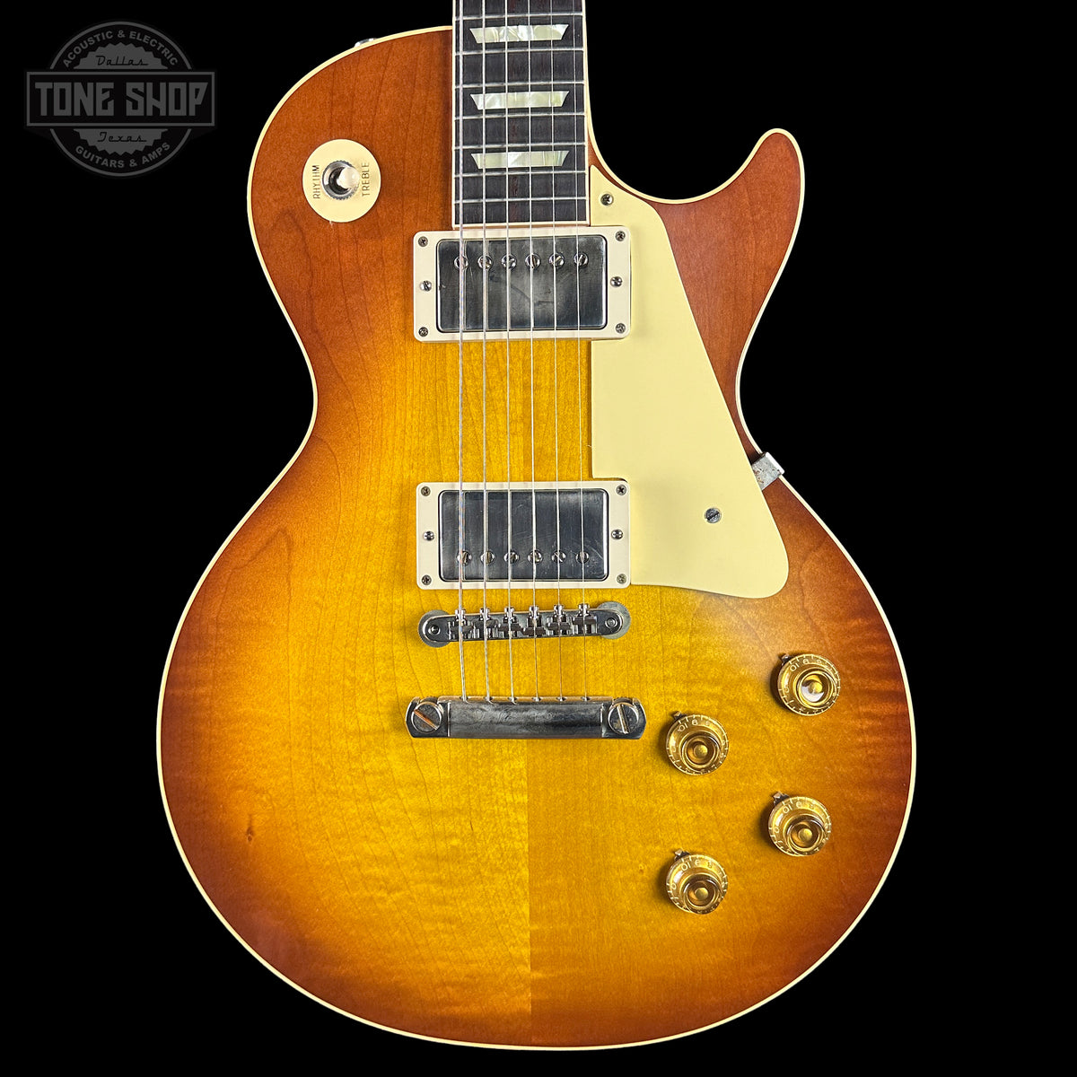 Electric guitar with a sunburst finish on a black background, featuring the Tone Shop logo.