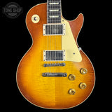 Electric guitar with a sunburst finish on a black background, featuring the Tone Shop logo.