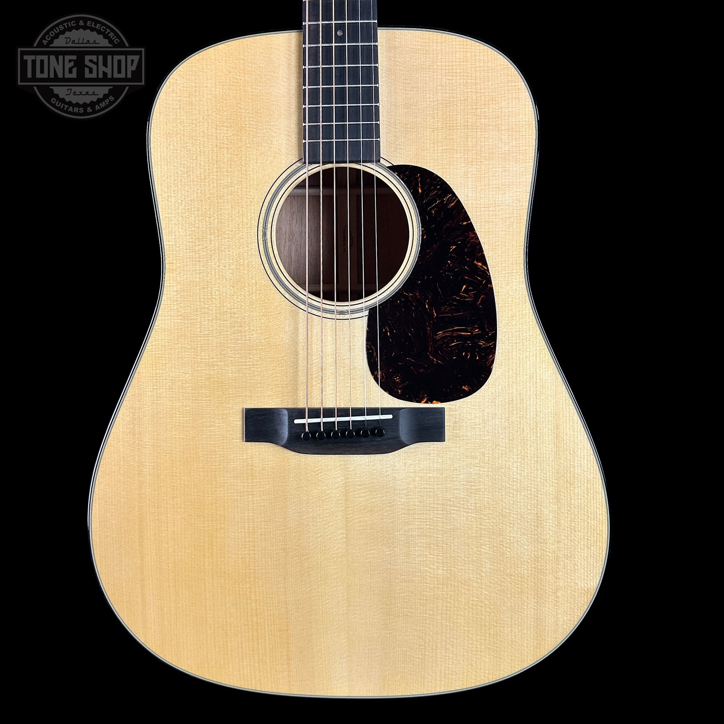 Acoustic guitar with a visible brand logo on a black background