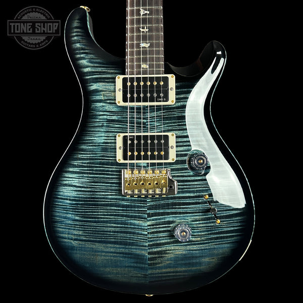 Electric guitar with a blue and black pattern on a black background, featuring the Tone Shop logo.