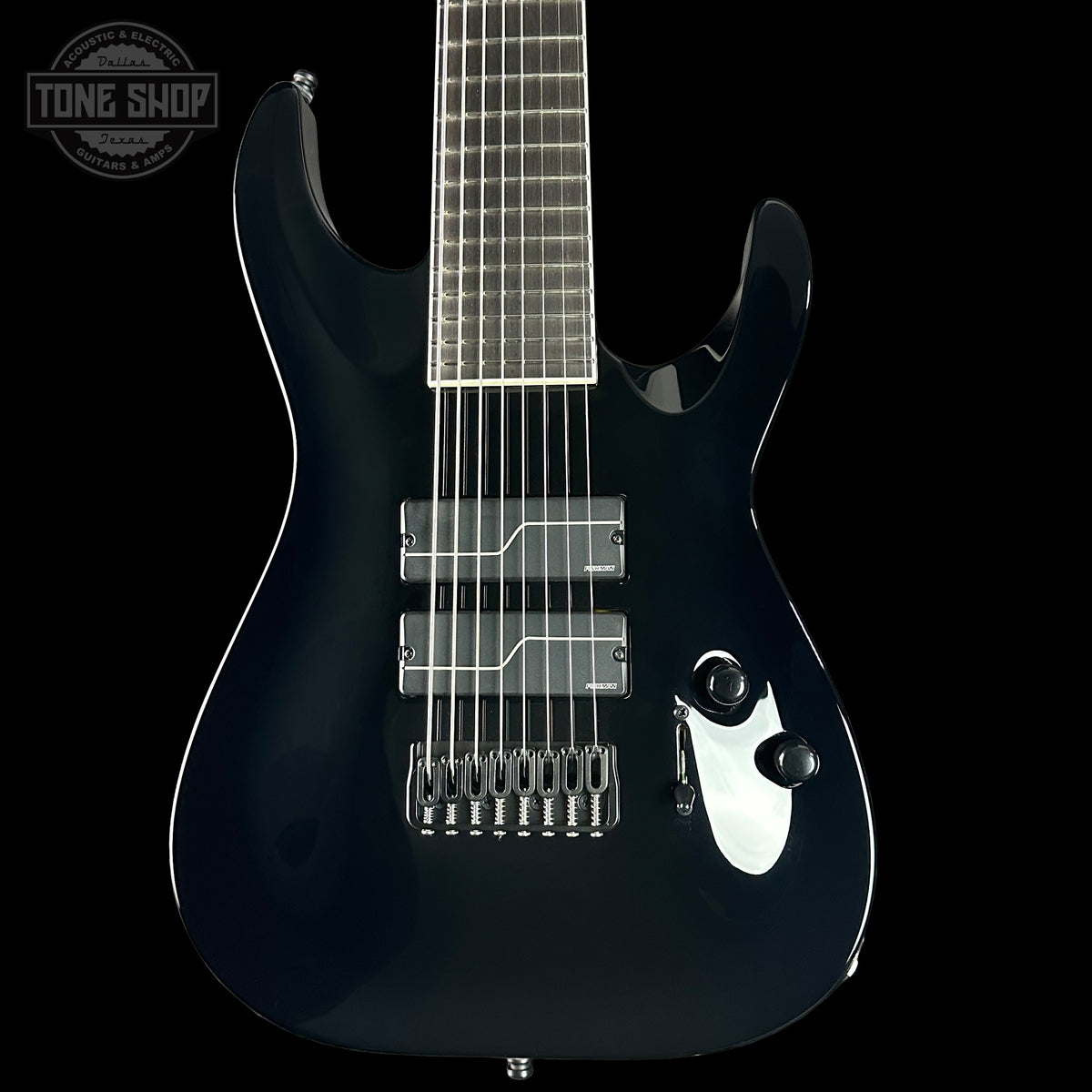 Black electric guitar on a black background with 'Tone Shop' logo.