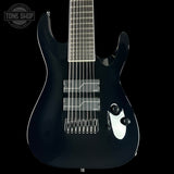 Black electric guitar on a black background with 'Tone Shop' logo.