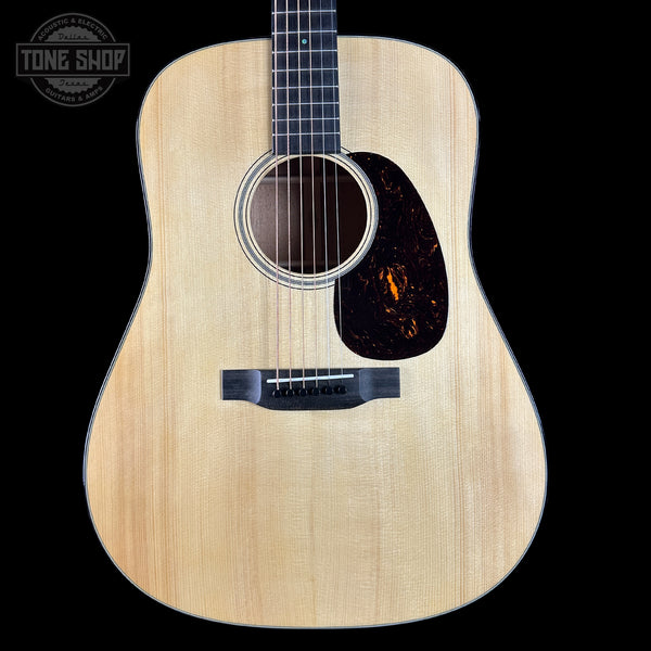 Acoustic guitar with a visible brand logo on a black background