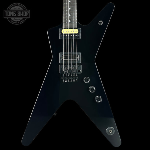 Black electric guitar with a unique body shape on a black background, featuring the 'Tone Shop' logo.