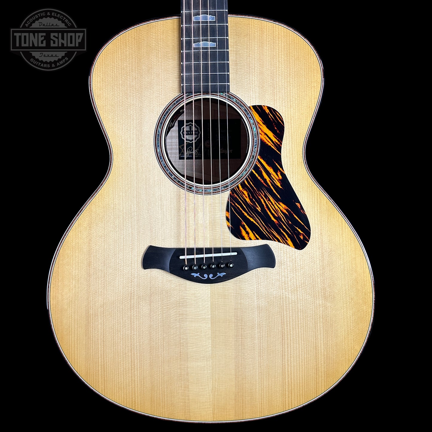 Acoustic guitar with a tiger stripe pattern on a black background, featuring the Tone Shop logo.