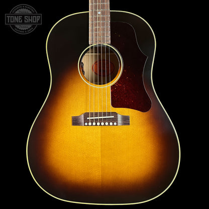 Acoustic guitar with a sunburst finish on a black background, featuring the Tone Shop logo.