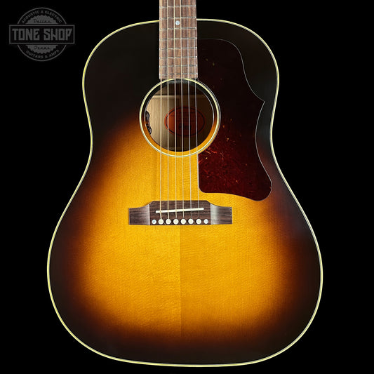 Acoustic guitar with a sunburst finish on a black background, featuring the Tone Shop logo.