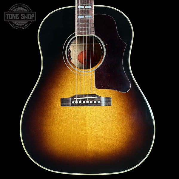 Acoustic guitar with a sunburst finish on a black background, featuring the Tone Shop logo.