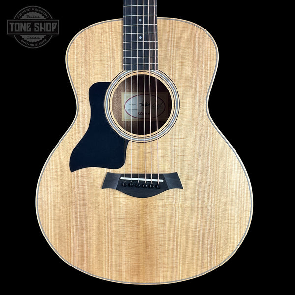 Acoustic guitar with a visible brand logo on a black background