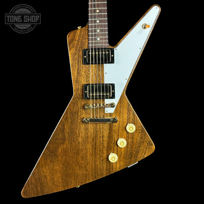 Wooden electric guitar with a white pickguard on a black background, featuring the Tone Shop logo.