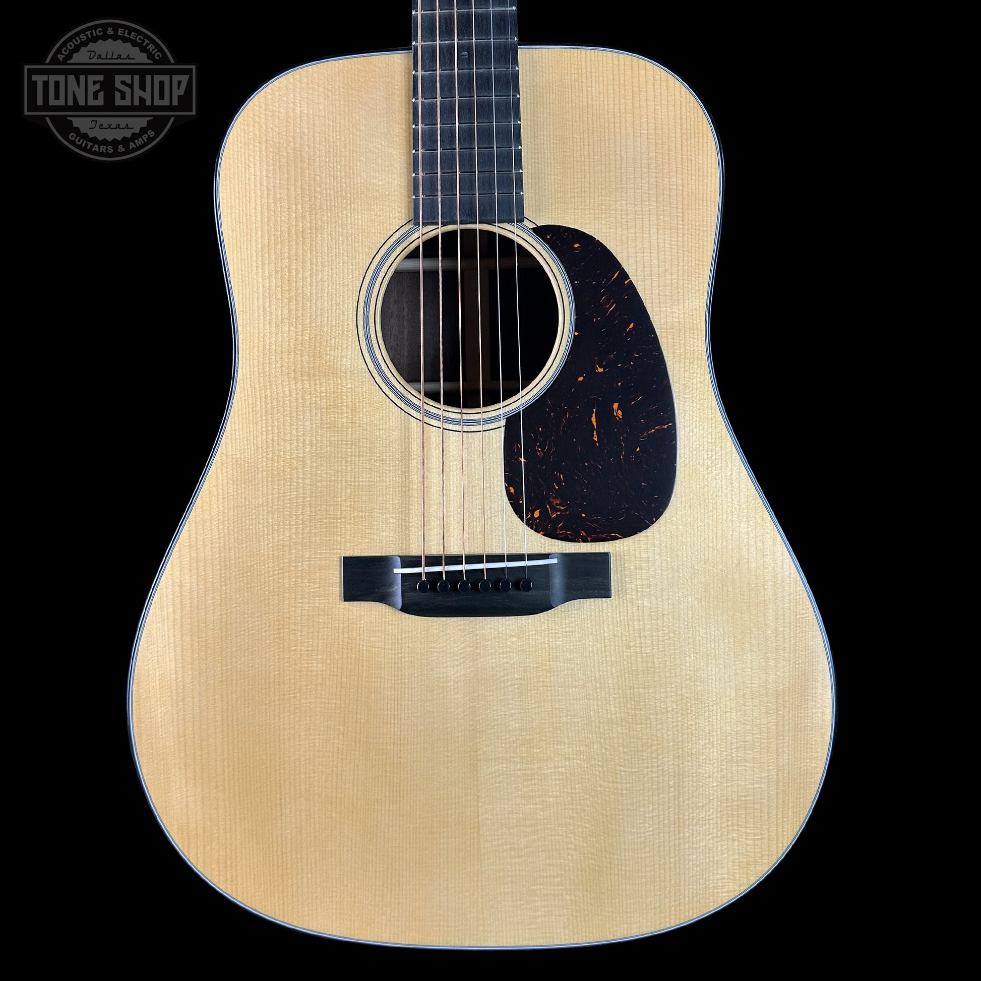 Acoustic guitar with a visible brand logo on a black background