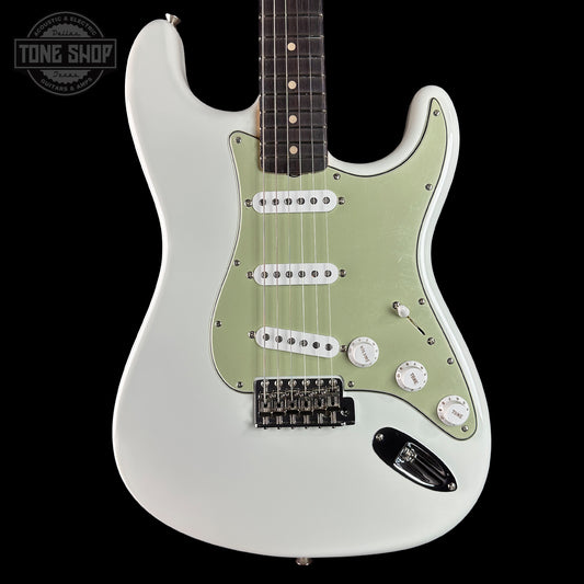 White electric guitar with a visible brand logo on a black background