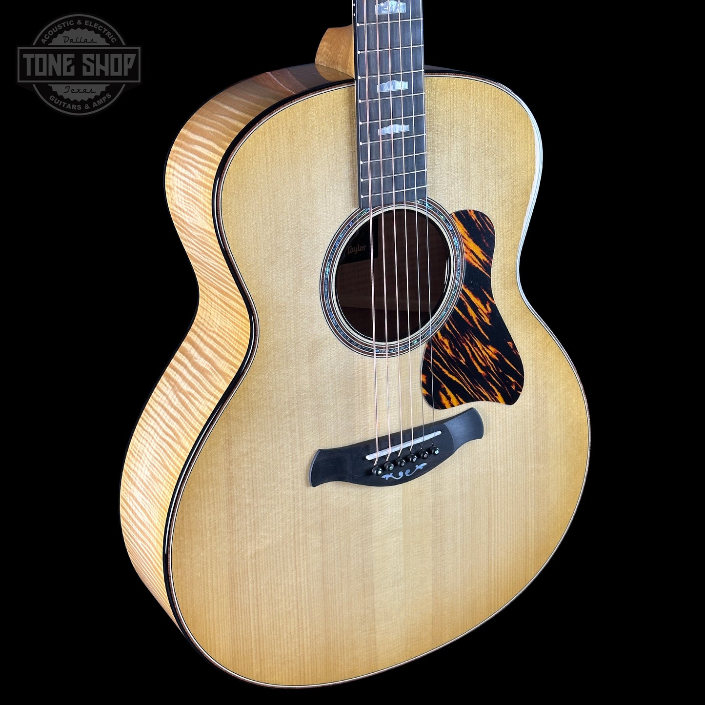 Acoustic guitar with flame pattern on a black background, featuring the Tone Shop logo.