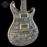 Electric guitar with a wavy wood finish on a black background, featuring the Tone Shop logo.