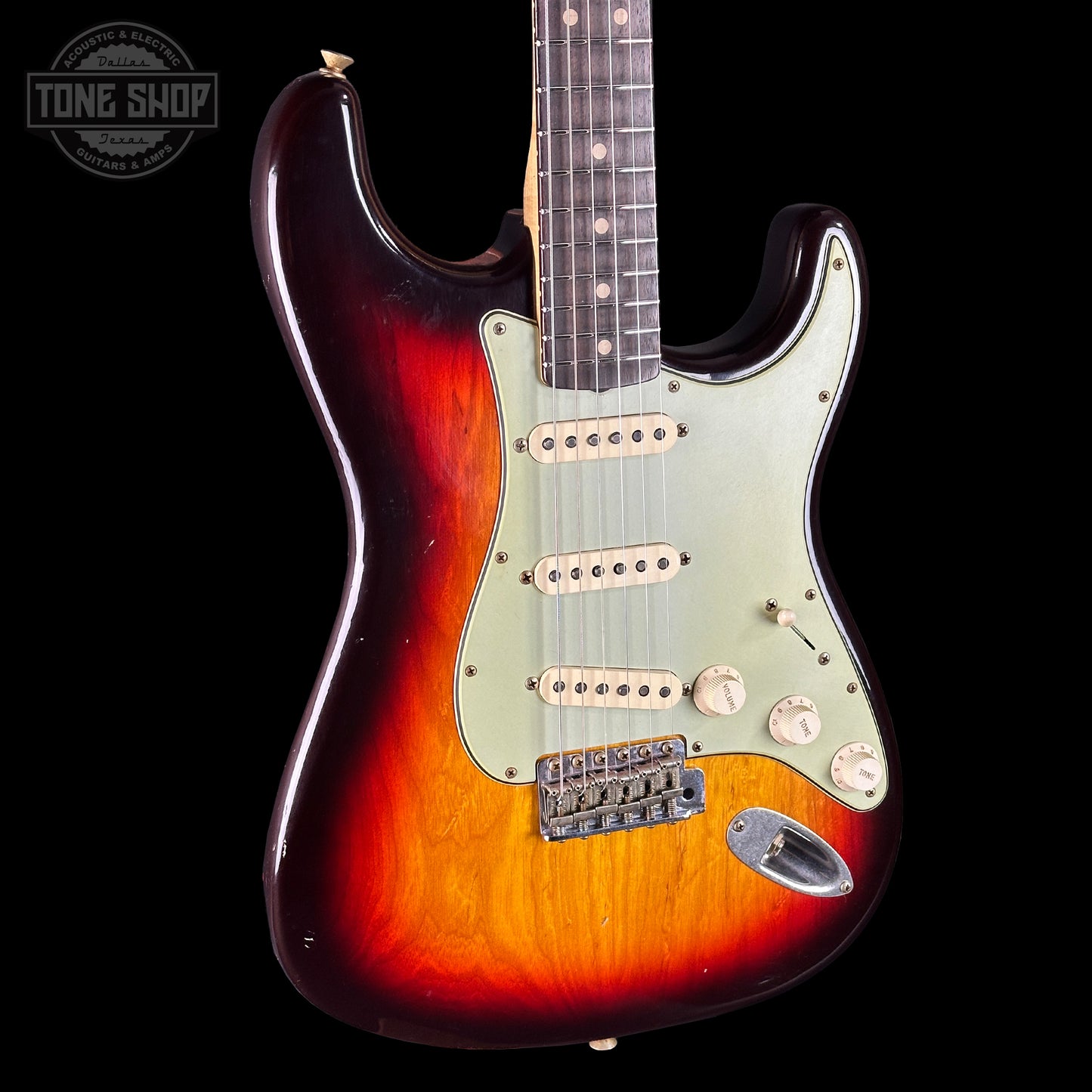 Electric guitar with a sunburst finish on a black background, featuring the Tone Shop logo.