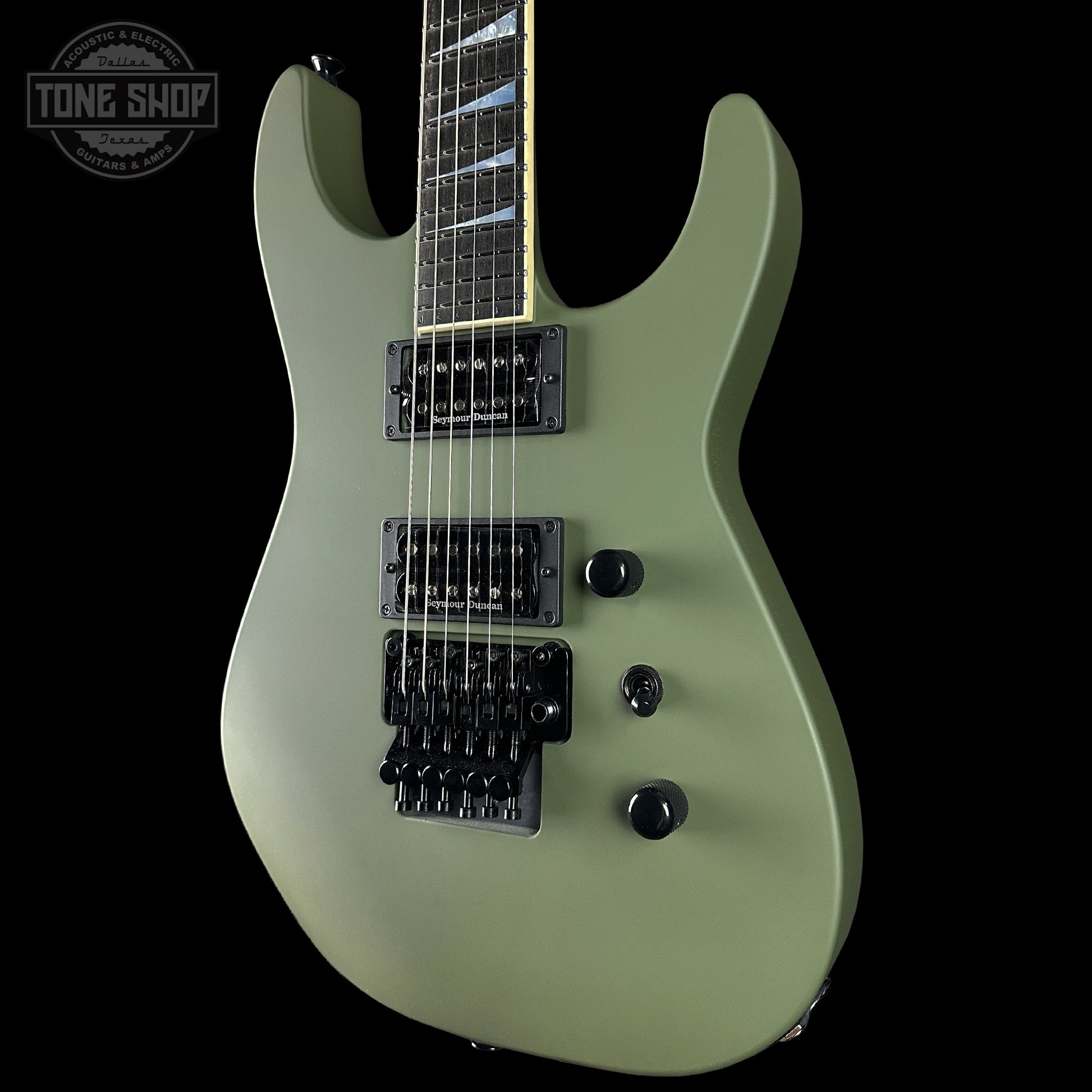 Green electric guitar with a black pickguard on a black background, featuring 'Tone Shop' branding.