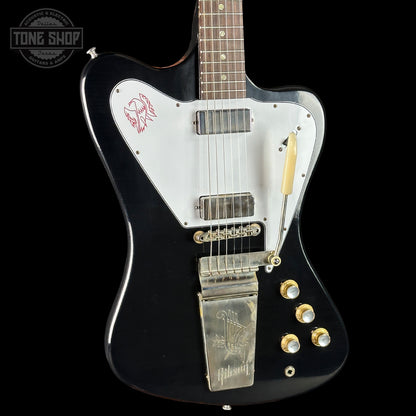 Black electric guitar with white pickguard on a black background, featuring the Tone Shop logo.