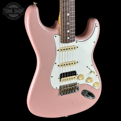 Pink electric guitar with a white pickguard on a black background, featuring the Tone Shop logo.
