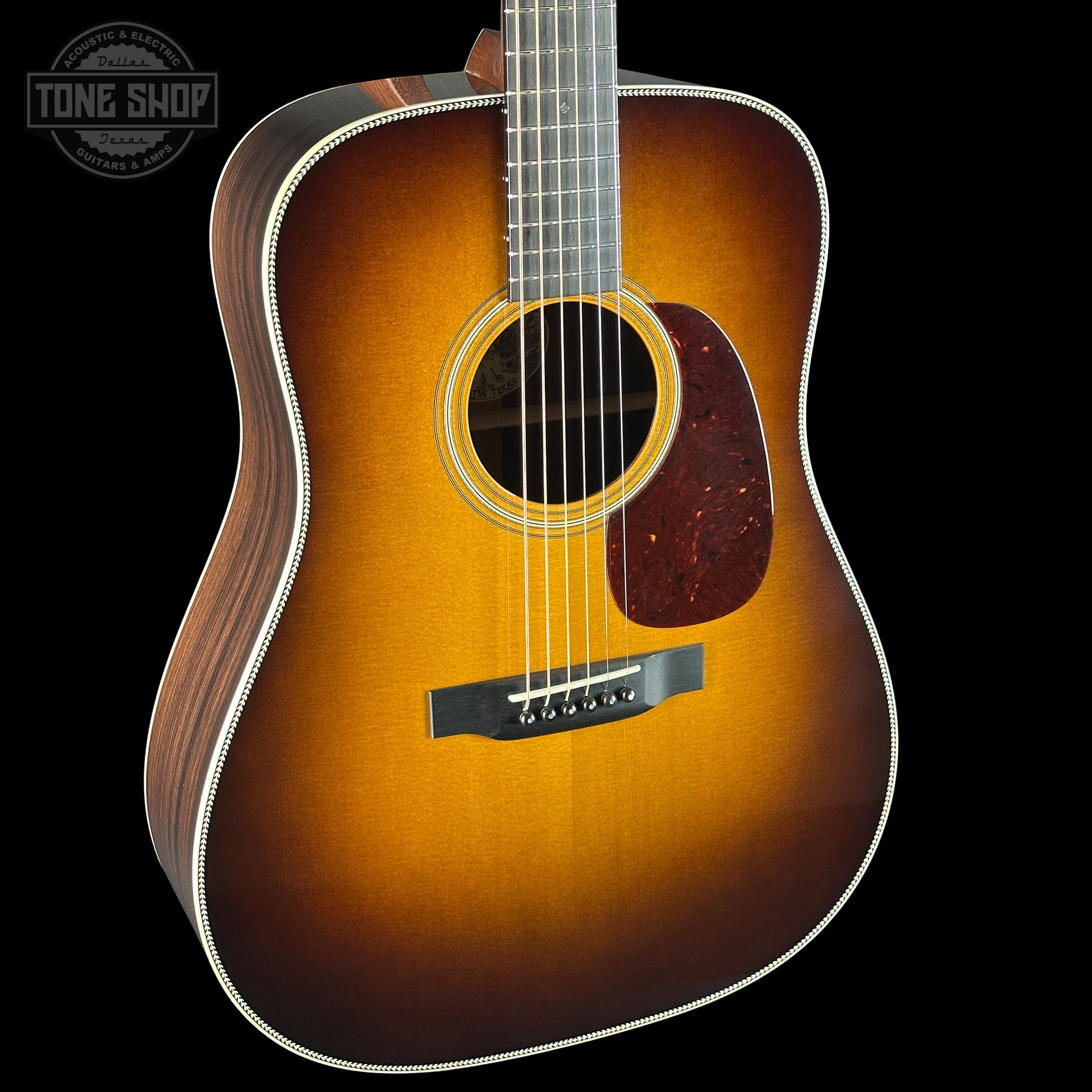 Acoustic guitar with a sunburst finish on a black background, featuring the Tone Shop logo.