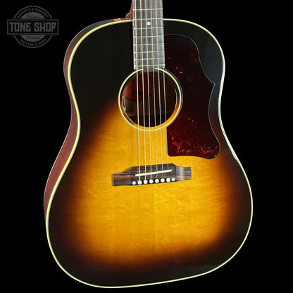 Acoustic guitar with a sunburst finish on a black background, featuring the Tone Shop logo.