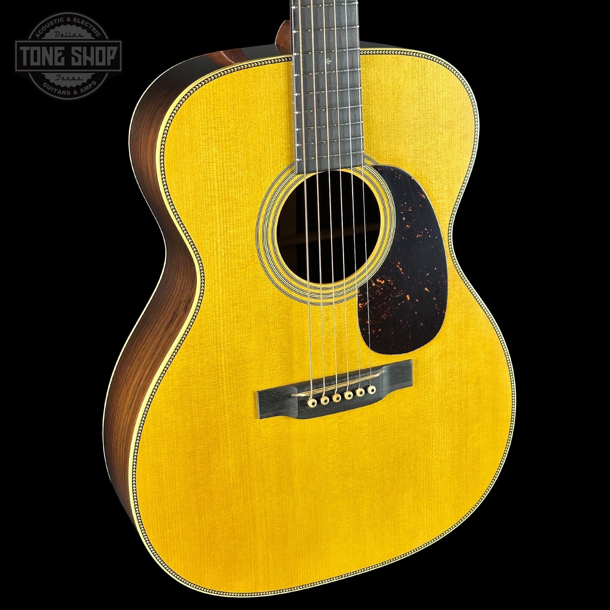 Acoustic guitar with a yellow finish on a black background, featuring the Tone Shop logo.
