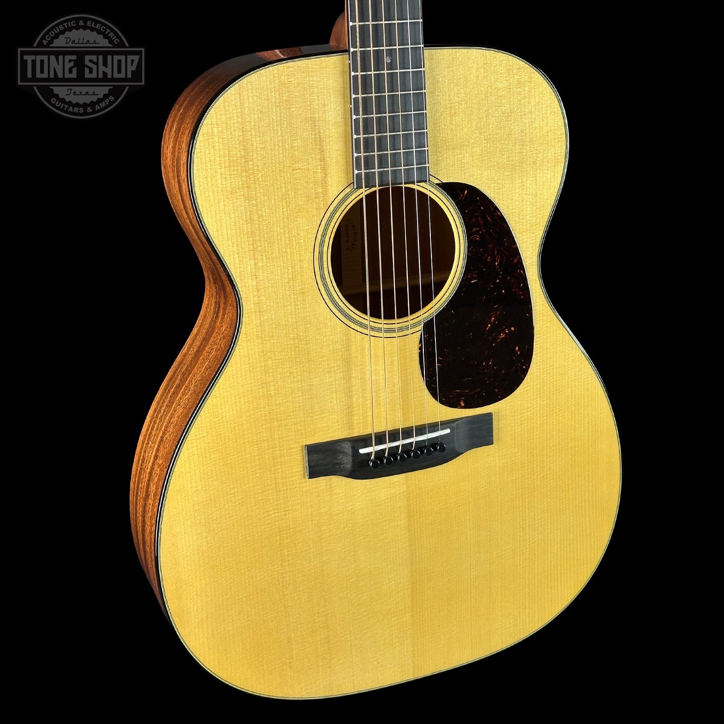 Acoustic guitar with a visible brand logo on a black background