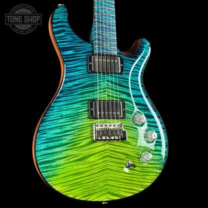 Electric guitar with a green and blue striped body on a black background, featuring the Tone Shop logo.