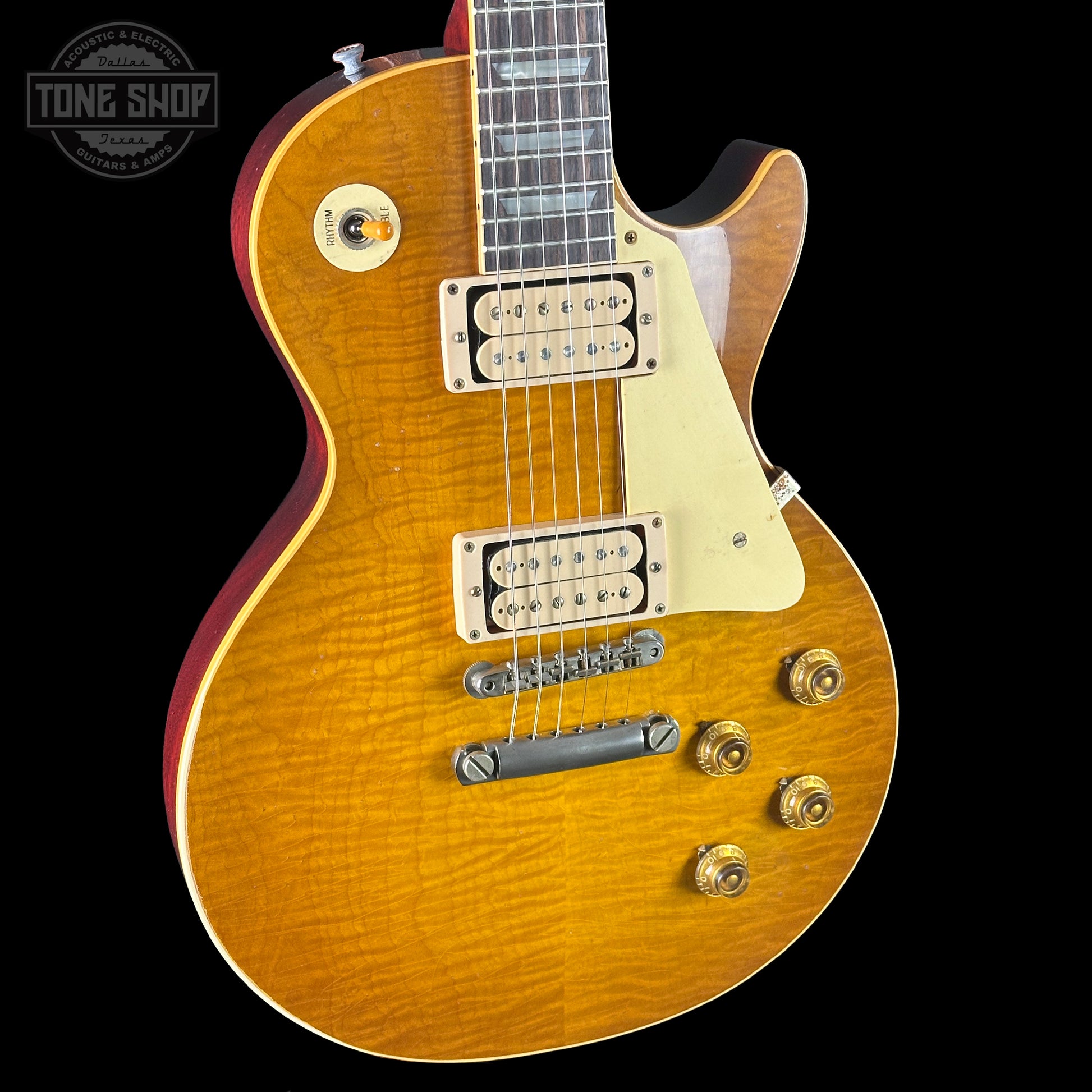 Electric guitar with a sunburst finish on a black background, featuring the Tone Shop logo.