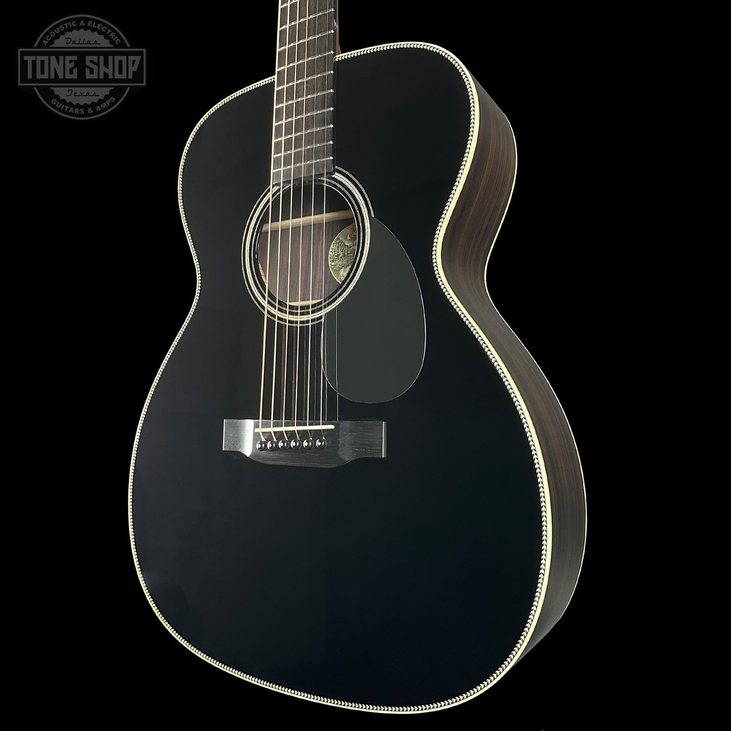 Black acoustic guitar on a black background with 'Tone Shop' logo.