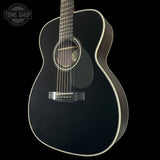 Black acoustic guitar on a black background with 'Tone Shop' logo.