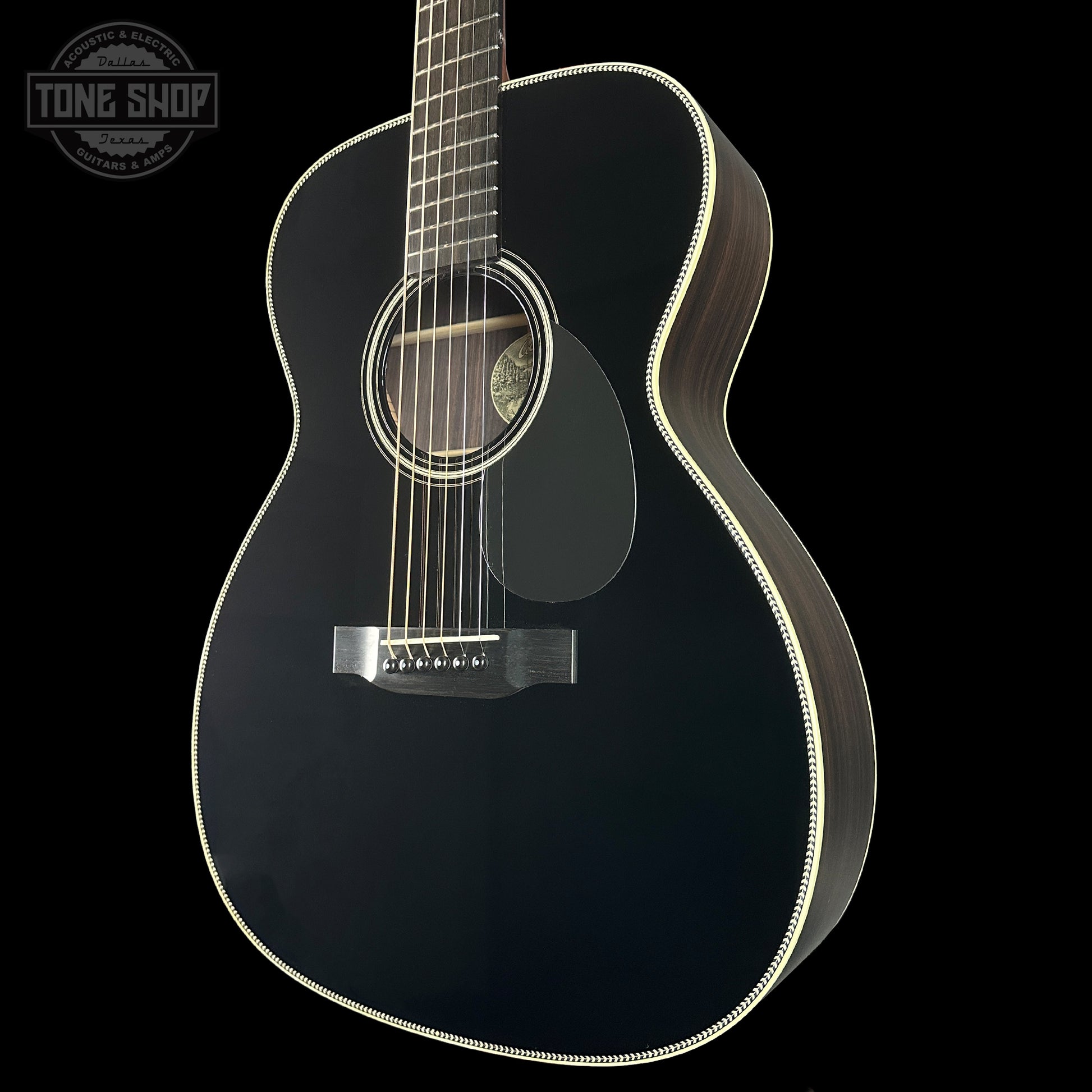 Black acoustic guitar on a black background with 'Tone Shop' logo.