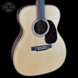 Acoustic guitar with a visible brand logo on a black background