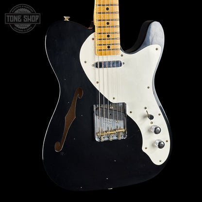 Black electric guitar with white pickguard on a black background, featuring 'Tone Shop' logo.