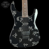 Black electric guitar with white geometric patterns on a black background, featuring 'Tone Shop' logo.