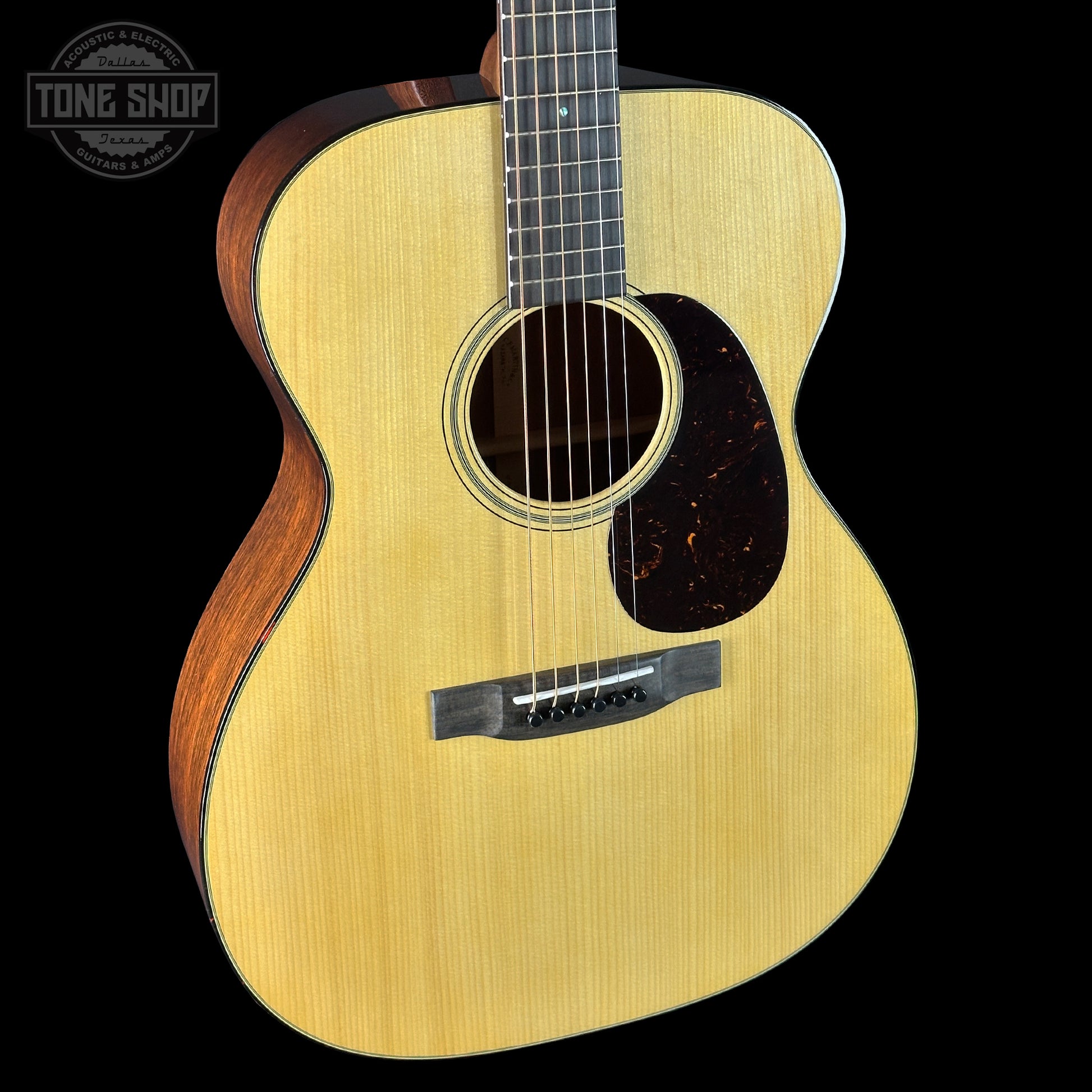 Acoustic guitar with a visible brand logo on a black background